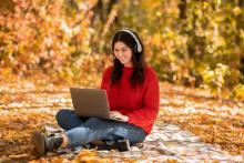 A woman works on her laptop outdoors